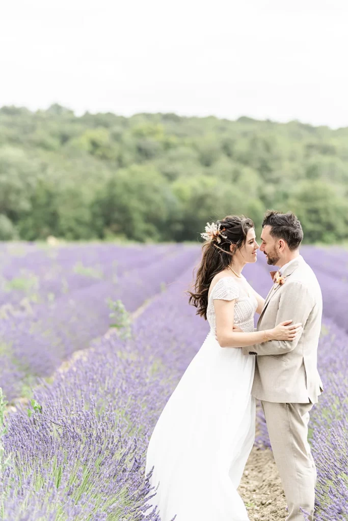 Couple de mariés dans les champs de lavandes lors d'un mariage au Domaine du Bijoutier à Grignan dans le Drôme provençale